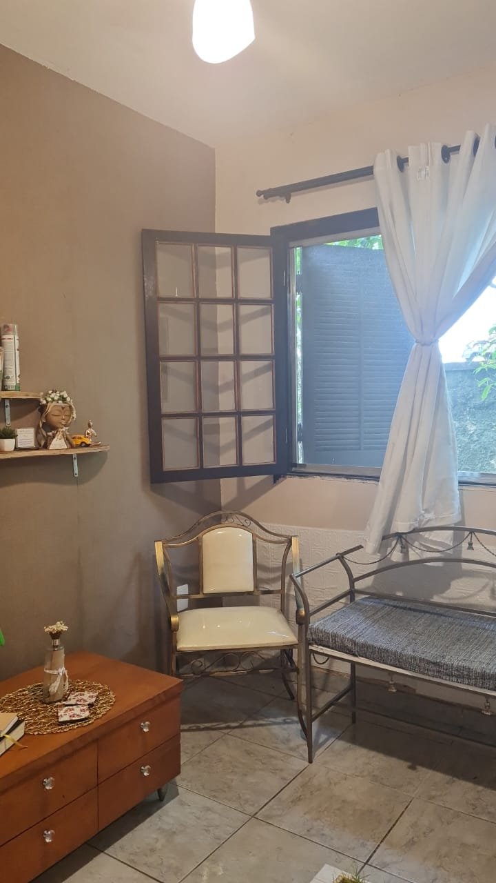 Ambiente interno da Casa com janela aberta, cadeiras e plantas