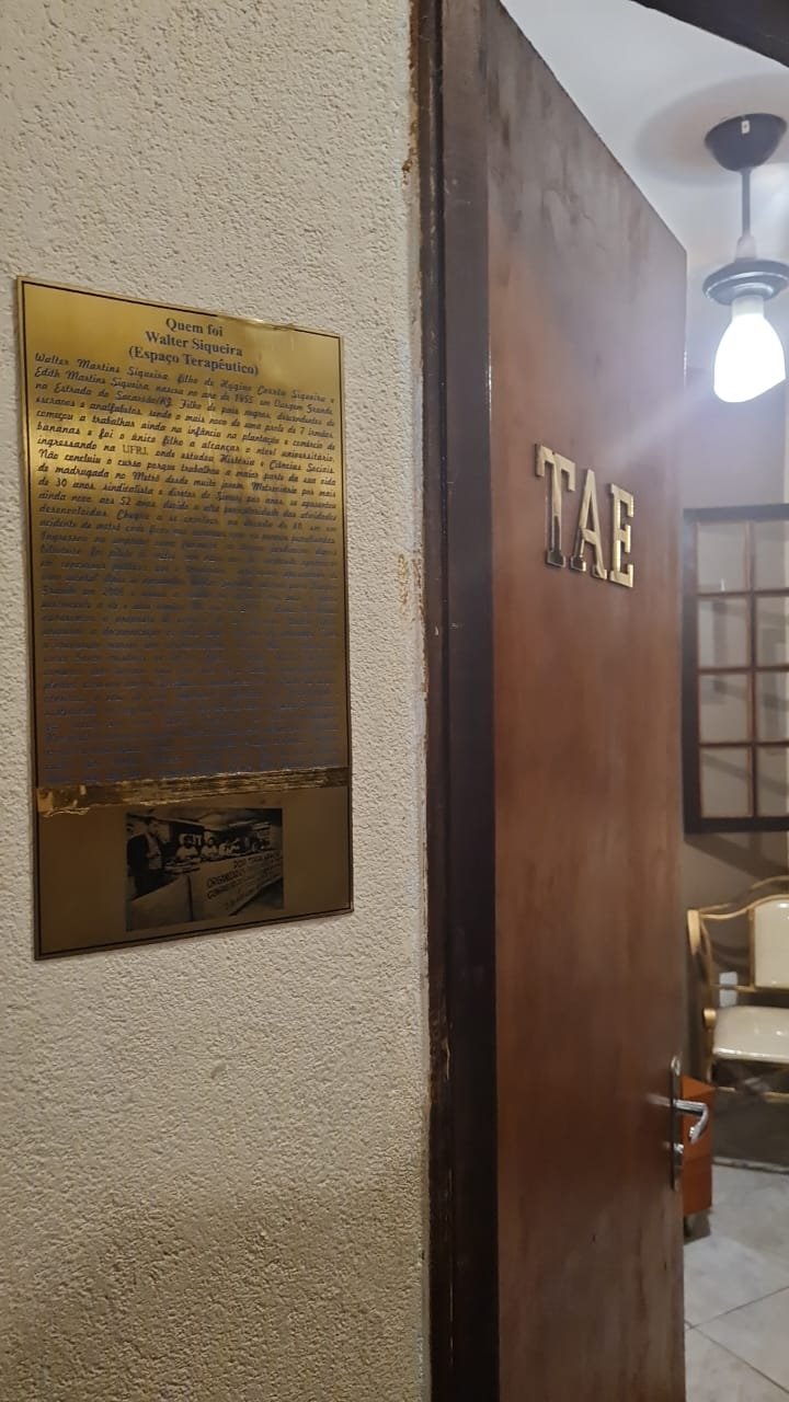 Placa com a história de Walter junto à entrada de um ambiente da Casa
